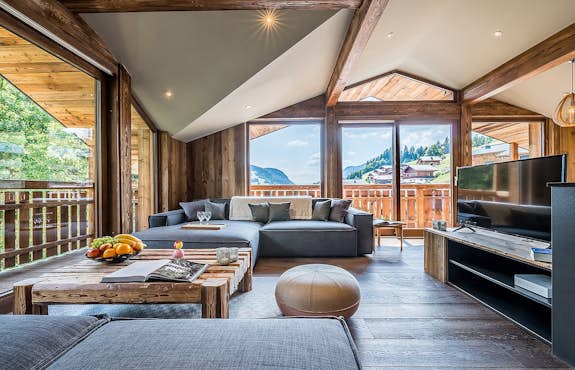 A living room with wooden beams and a view of the mountains.
