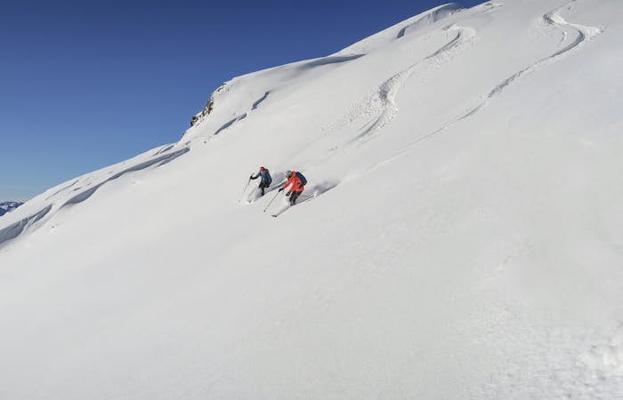 Two people skiing on slopes between Arc 1600 and Arc 1800 in Les Arcs