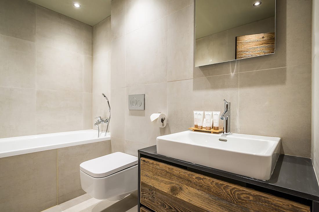 Light grey modern bathroom with bathtub at Moulin I luxury chalet in Les Gets