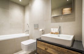 Les Gets accommodation - Chalet Moulin I - Light grey modern bathroom with bathtub at Moulin I luxury chalet in Les Gets