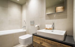 Les Gets accommodation - Chalet Moulin I - Light grey modern bathroom with bathtub at Moulin I luxury chalet in Les Gets