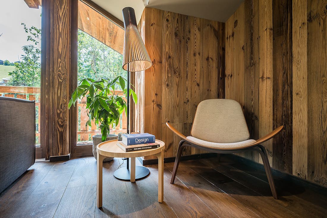 Les Gets location - Chalet Moulin I - Coin lecture avec chaise et table basse en bois dans le chalet de luxe éco-responsable Moulin I Les Gets