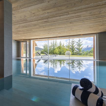 An indoor swimming pool with a view of the mountains.