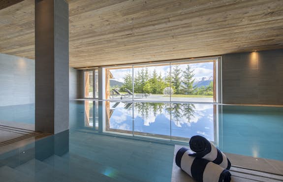 An indoor swimming pool with a view of the mountains.