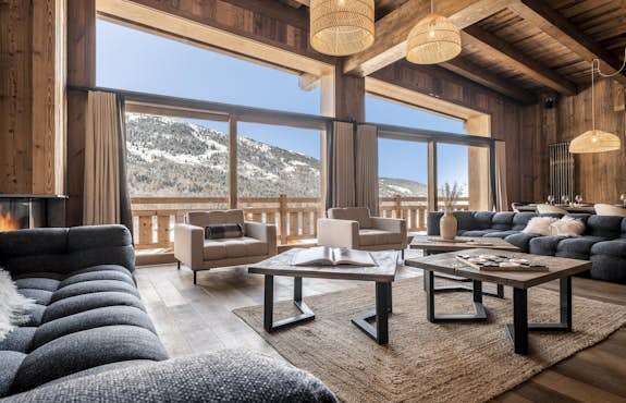 A living room with a fireplace and a view of the mountains.