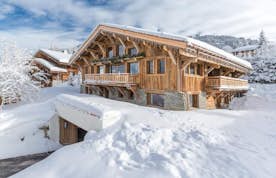 Megève location - Chalet Orcia - A house in the mountains with a wooden roof.