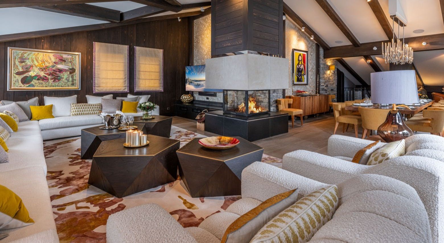 Luxurious open-plan living and dining room with plush white sofas, geometric dark coffee tables, central glass fireplace, wood beams. Luxurious open-plan living and dining room with plush white sofas, geometric dark coffee tables, central glass fireplace, wood beams.