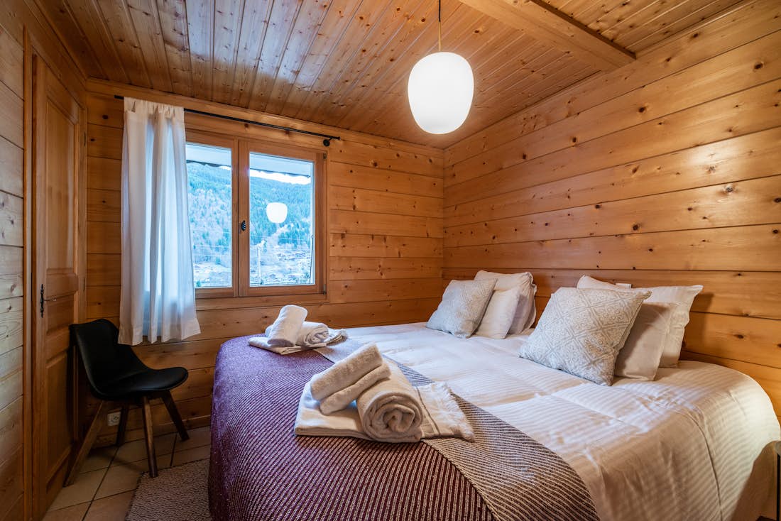 Morzine accommodation - Chalet Doux Abri - Wooden double bedroom with ample cupboard space and landscape views at eco-friendly chalet Doux-Abri Morzine