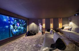 Megeve accommodation - Chalet Orcia - A home theater with a large screen and couches.