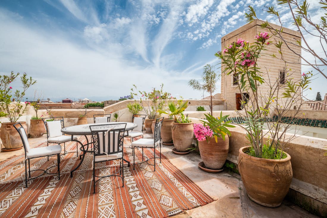 Rooftop terrace with table and chairs at luxury Adilah riad in Marrakech