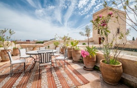 Rooftop terrace with table and chairs at luxury Adilah riad in Marrakech