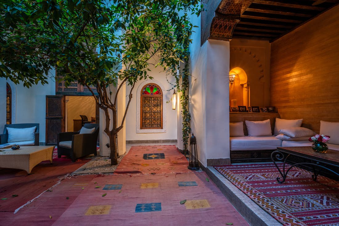 Patio with red berber rugs and lemon tree at Adilah riad in Marrakech