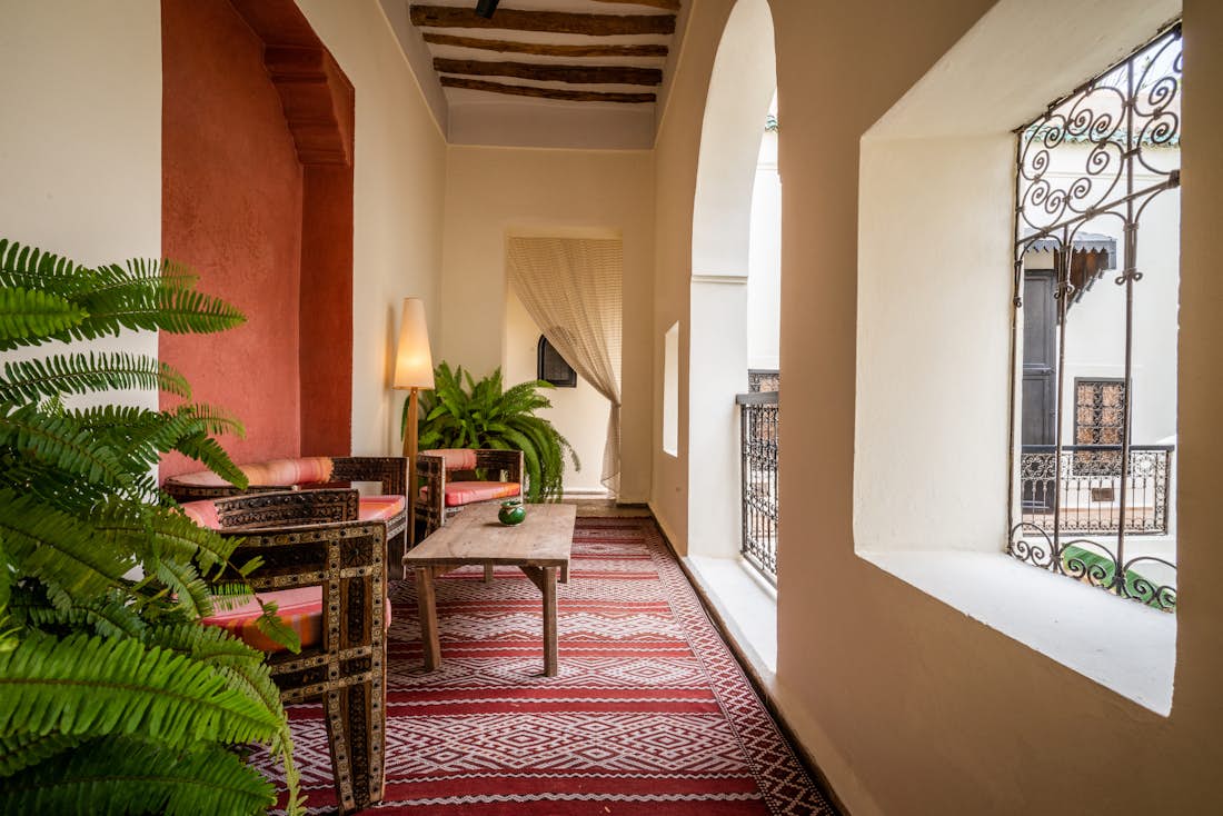 Outside covered seating area featuring a red and white berber rug at Adilah riad in Marrakech