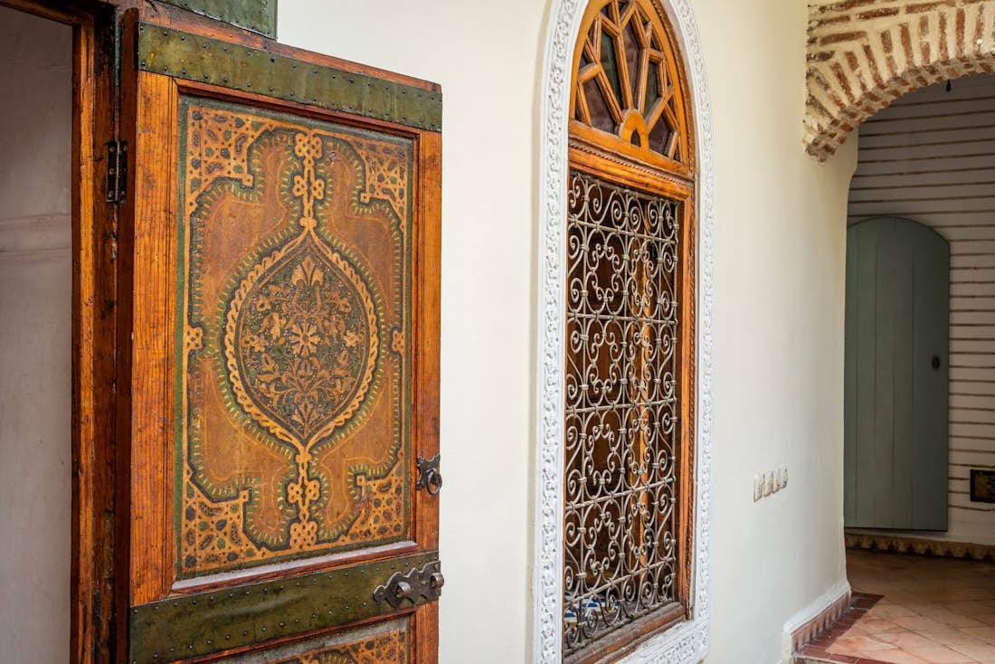 Traditional moroccan wooden door with paintings at Adilah riad in Marrakech