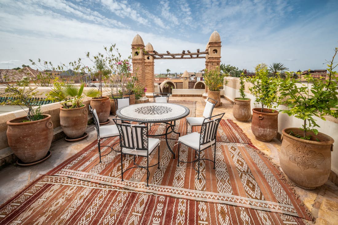 Rooftop terrace with table and chairs at Adilah riad in Marrakech
