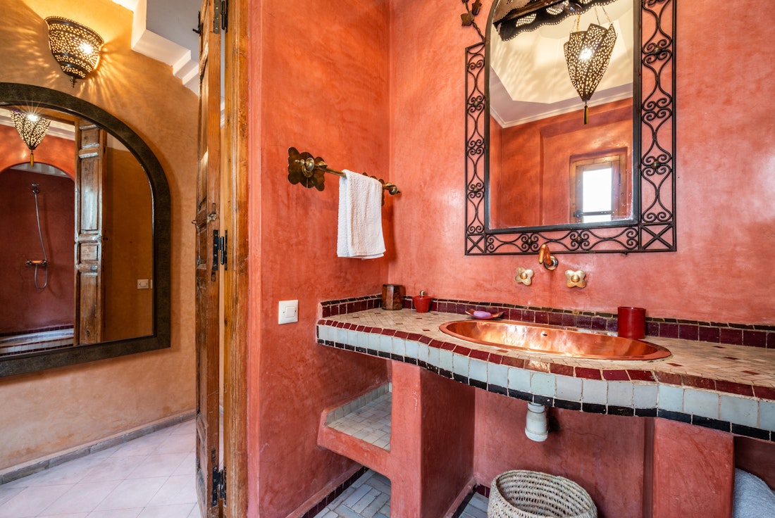 Terracotta-coloured walls in the bathroom of Adilah riad in Marrakech