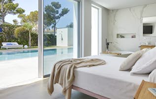 Costa Brava location - Villa Toi & Moi - A bed in a bedroom with a view of the pool.