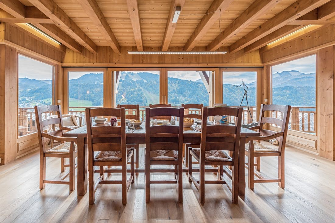 Large wooden dining table with views over the Alps at Omaroo II luxury chalet in Morzine