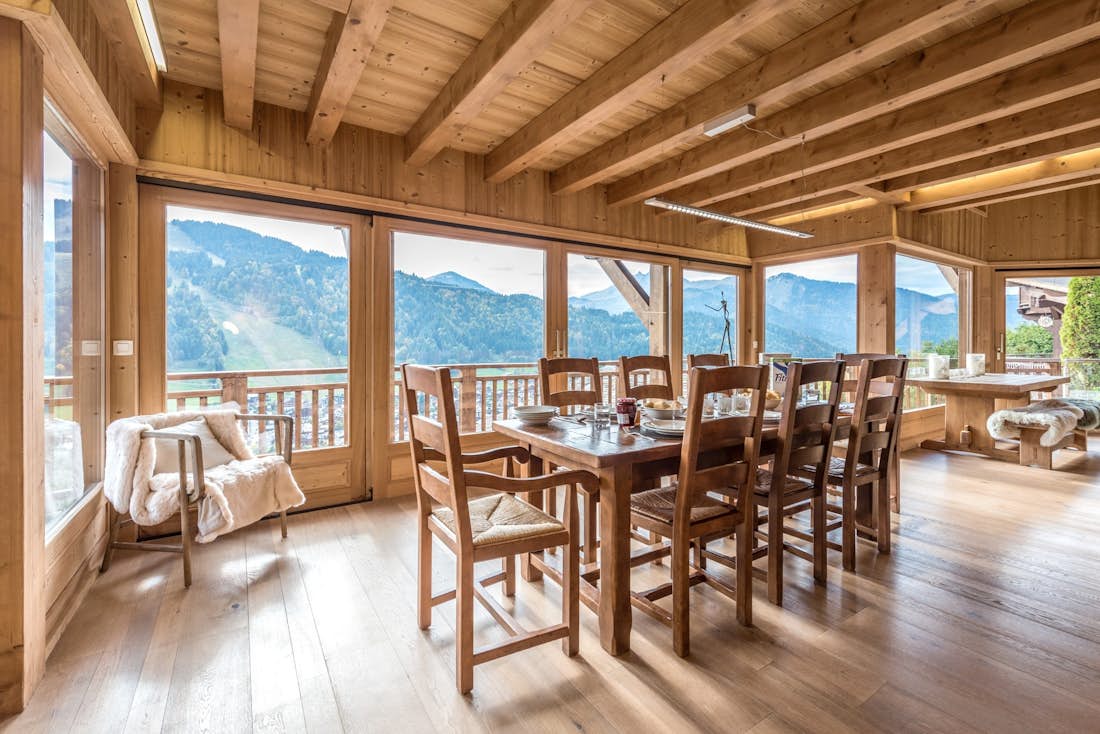 Wooden dining table and armchair with views over the Alps at Omaroo II luxury chalet in Morzine
