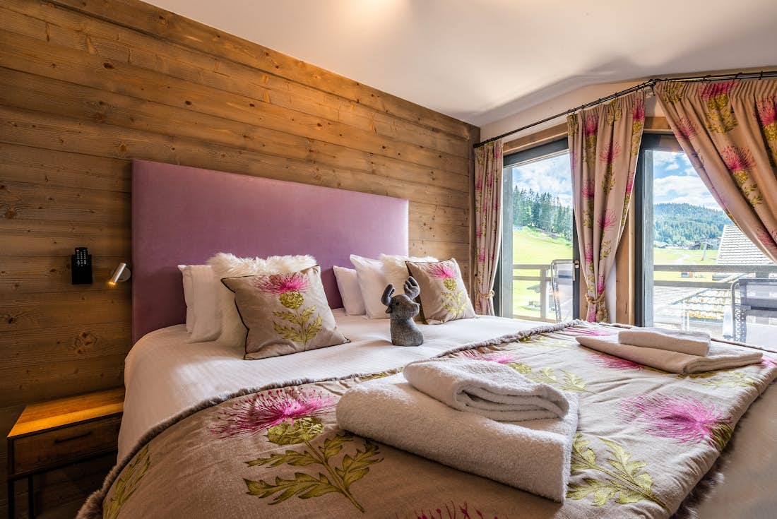 Ensuite Bedroom with wooden walls colourful pillows eco-friendly apartment Ozigo Les Gets