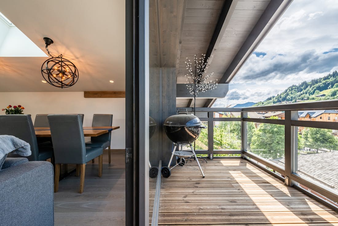 Terrasse bois avec barbecue vue montagnes services hôteliers Ozigo appartement Les Gets