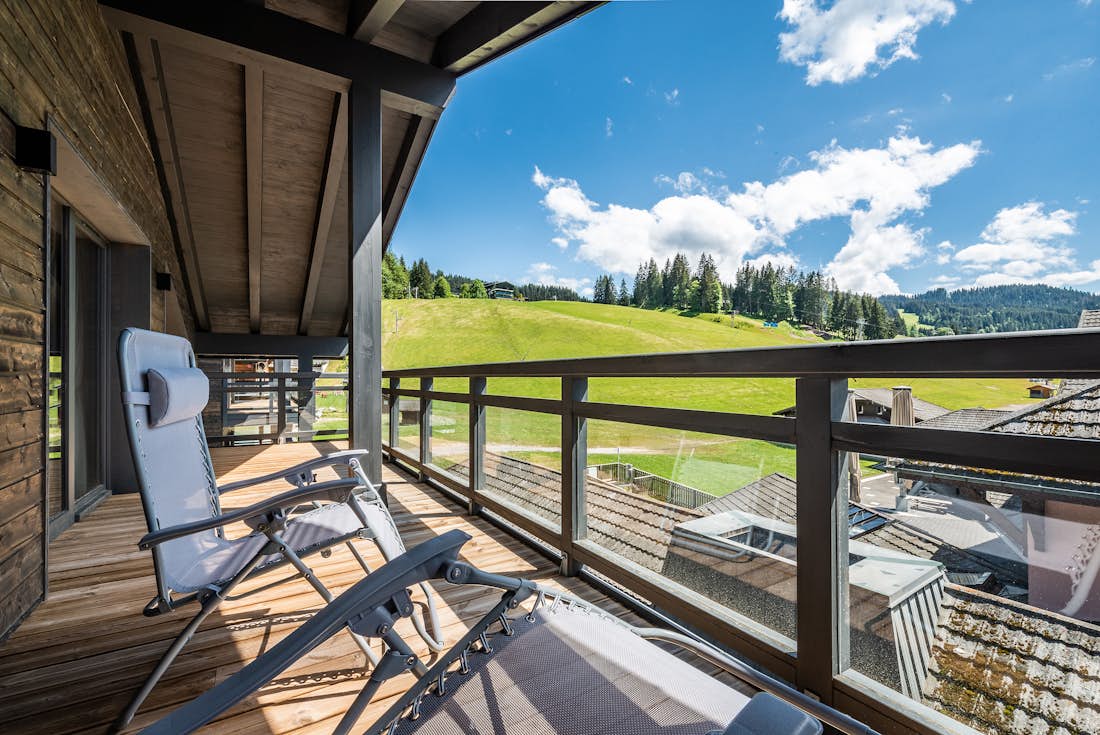 Terrasse bois chaises longues vue montagne dans servies hôteliers Ozigo appartement Les Gets