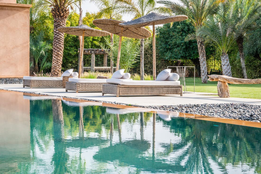Private pool with raffia daybeds at Marhba luxury private villa in Marrakech