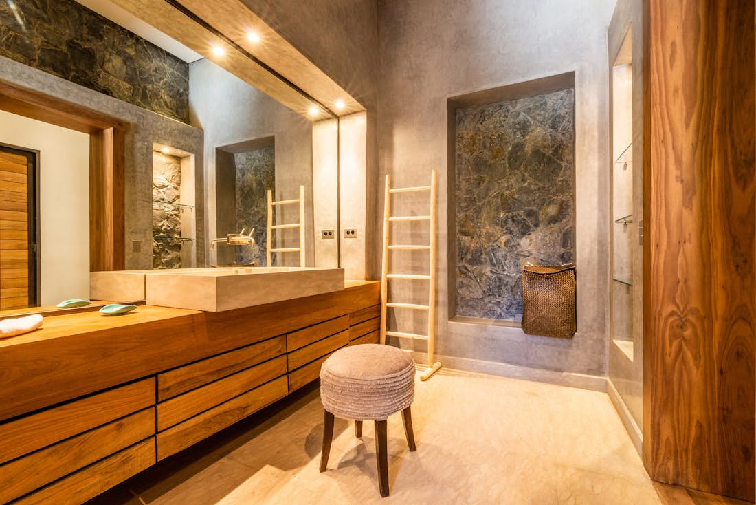 Ethnic bathroom with concrete sink and wooden bathroom furniture at Marhba luxury private villa in Marrakech