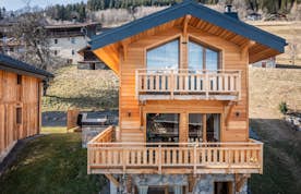 Morzine location - Chalet Bellatrix - A wooden house in the mountains with a balcony.