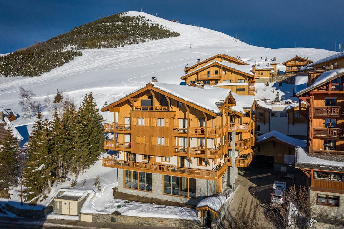 Alpe d’Huez location - Appartement Juglans - Wooden and snowy outdoor of the luxurious residence and ski in ski out apartment Juglans in Alpe d'Huez