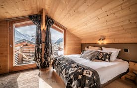 Chamonix location - Chalet Inari - A bed in a wooden room.
