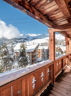 Verbier alojamiento - Apartmento Ayous - A wooden balcony overlooking snowy mountains and a ski lift.