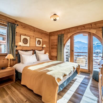 A bedroom with wooden walls and a large bed.