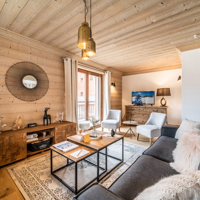 Espace Diamant  Property management A living room in a chalet with wooden walls.