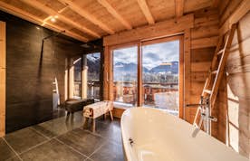 Morzine accommodation - Chalet Heavenly - A bathroom with a bathtub and a view of the mountains.
