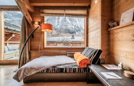 Chamonix location - Chalet Inari - A living room with a wooden staircase and a dining table.