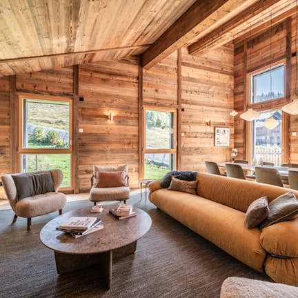 A living room in a log cabin with large windows.