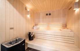 Morzine location - Chalet Bellatrix - A sauna room with a wooden bench and a towel.