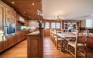 Verbier accommodation - Apartment Ayous - A kitchen with wooden floors and a dining table.