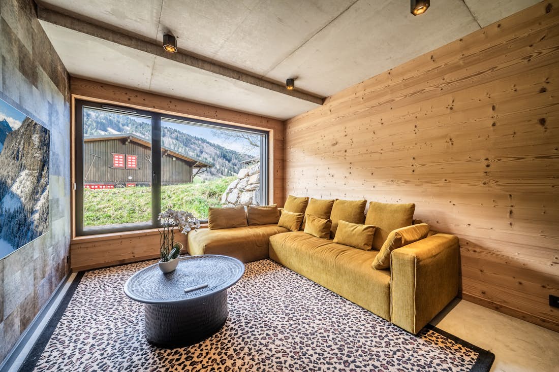 Verbier alojamiento - Chalet Nelcote - Spacious TV room with long yellow sofa in alps chalet Nelcôte Morzine
