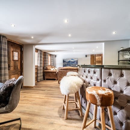 A living room with a bar and stools.