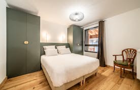 Les Gets accommodation - Apartment Edelweiss - A bedroom with wooden floors and a bed.