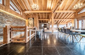 Morzine accommodation - Chalet Heavenly - A dining room with wooden beams and a stone floor.