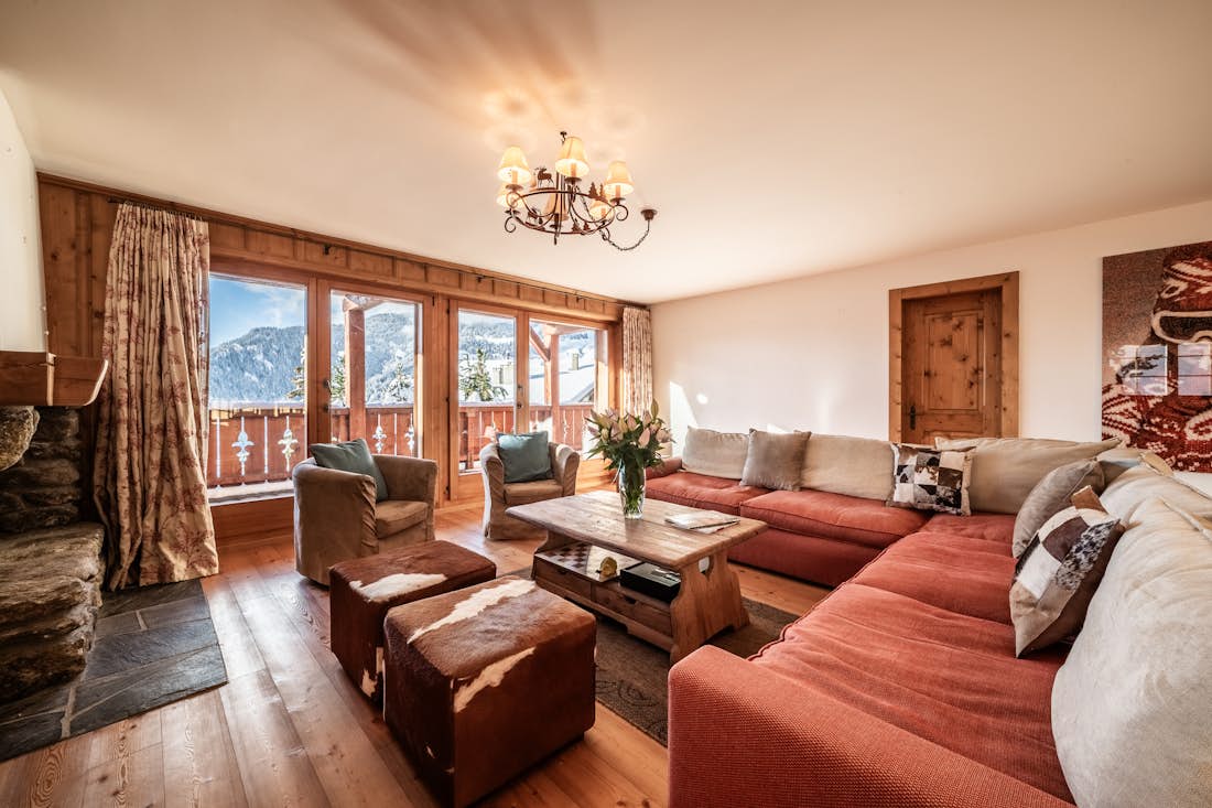Verbier location - Appartement Ayous - A living room with a fireplace and a view of the mountains.