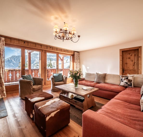 Verbier location - Appartement Ayous - A living room with a fireplace and a view of the mountains.