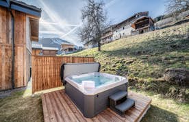Morzine accommodation - Chalet Bellatrix - A wooden house with a hot tub in front of it.