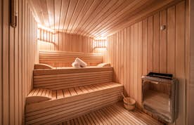 Morzine location - Chalet Heavenly - A wooden sauna room with a towel on the floor.