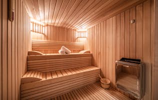 Morzine accommodation - Chalet Heavenly - A wooden sauna room with a towel on the floor.