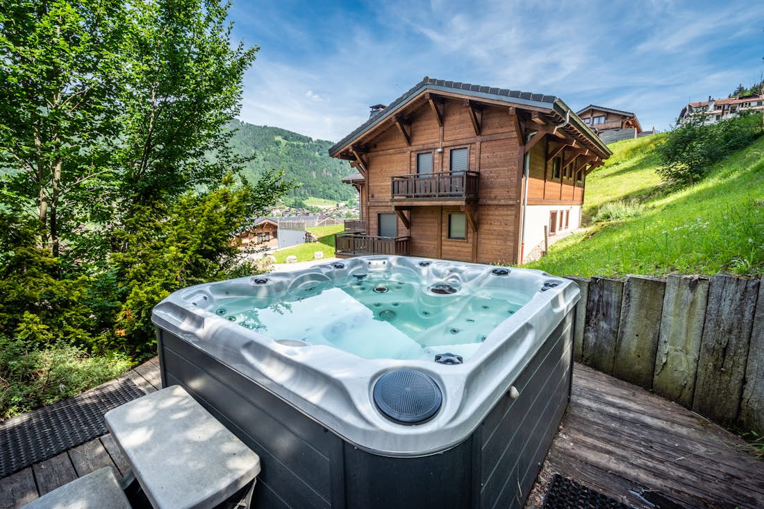 Morzine location - Chalet Doux Abri - Outdoor hot tub on the terrace with mountain views at the family chalet Doux Abri in Morzine