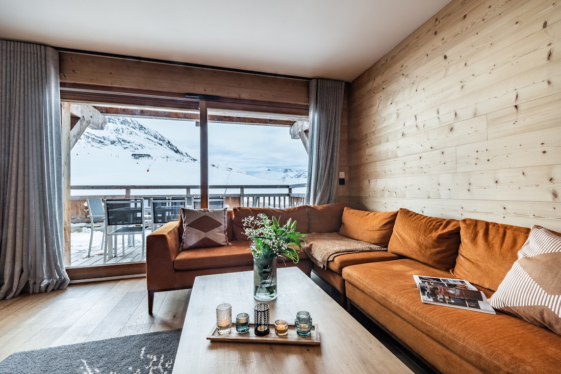 Salon avec canapé d'angle orange en velours à la location Wapa à l'Alpe d'Huez